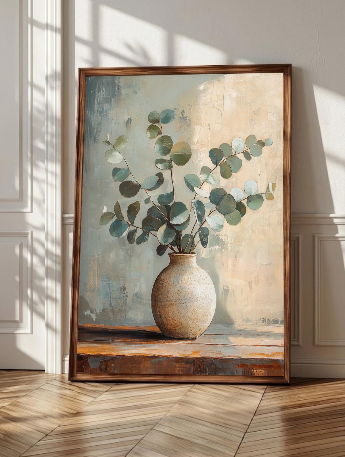 Eucalyptus wall art: silvery eucalyptus leaves resting in a handmade ceramic vase